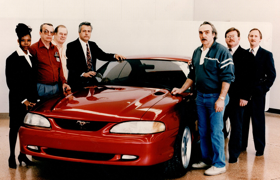 Emeline King standing with other Ford Motor Co. employees near a then-new model of the Mustang