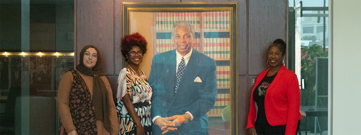 New DEAL activists posing with painting of Damon J. Keith