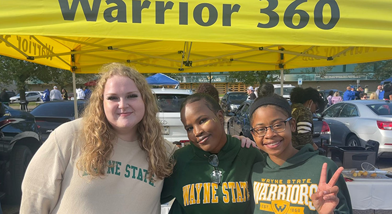 three female students photographed together wearing Wayne State sweatshirts